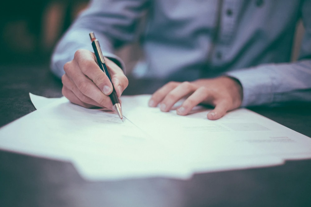 Documents are reviewed and assessed using a pen.