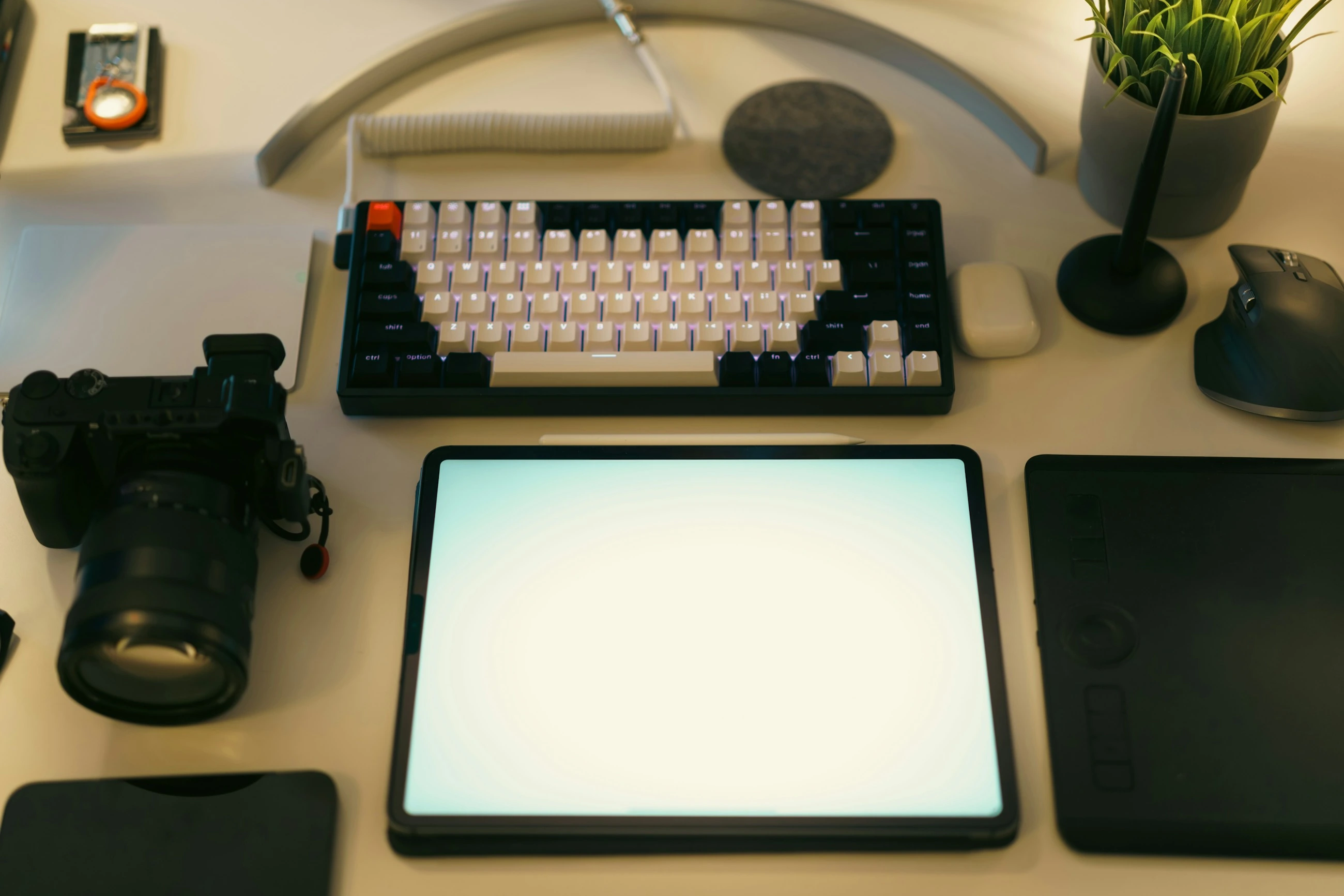 A creative workspace with a computer, graphics tablet and camera.