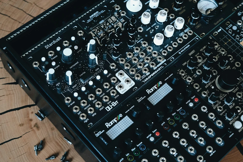 A synthesiser with buttons and cables in a music studio.