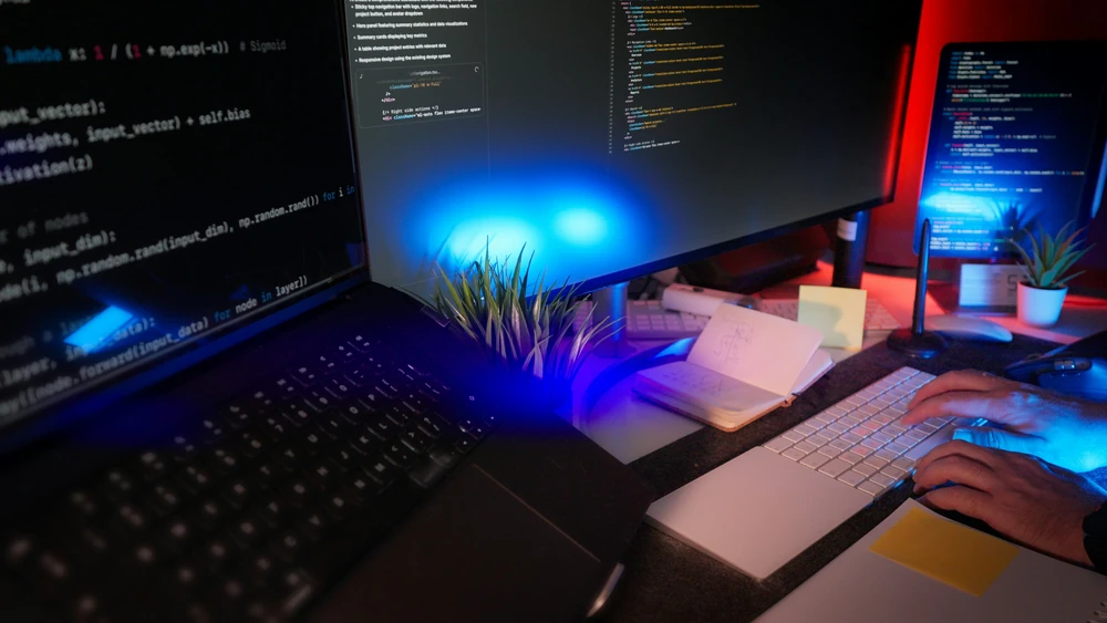 A developer is working on software across several computer screens.
