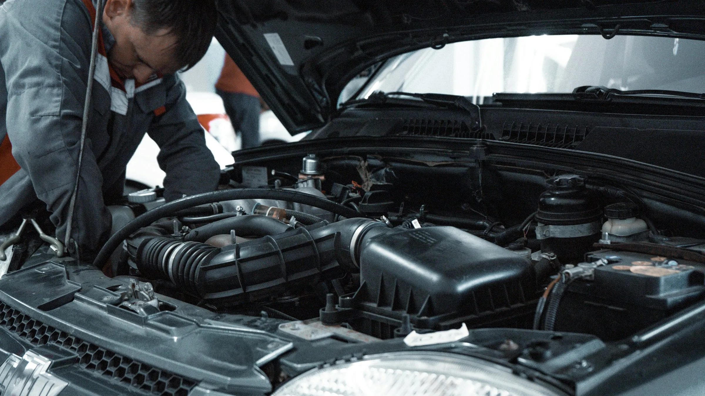 A car mechanic at work under the bonnet